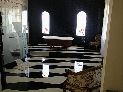 mezcla de ceramicos con patrones de corte especialmente diseñados con marmol, muebles antiguos con ventanas emplomadas y una tina reciclada como punto focal,hacen de este baño una zona para la relajacion y el descanso